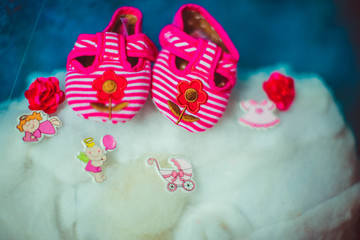 little pink slippers lying on a bed