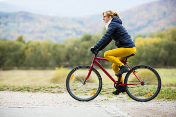 Obraz premium Urban biking - woman riding bike in city park 