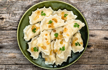 Homemade dumplings with fried onion on plate, top view, cooking concept