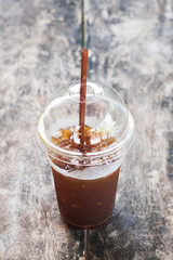 A cup of Ice coffee on wooden table in coffee shop.