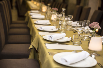 Stylish restaurant table with plates, glasses and napkins