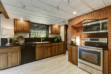 Kitchen area with red brick wall and built in appliances
