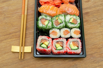 Japanese sushi and chopsticks on the wooden background