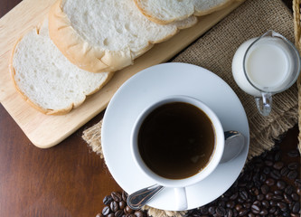 Obraz na płótnie Canvas Crispy fresh croissants and cup of coffee espresso on a rustic w