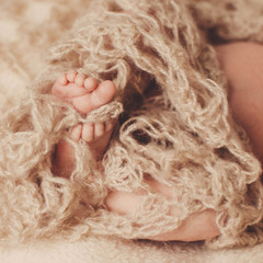 amazing  baby sleeps under a brown scarf