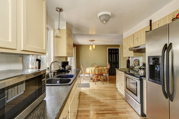 Narrow kitchen room interior with stainless steel appliances