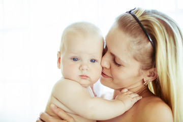 Mother clothes her eyes while leaning to a little child