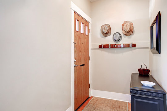 Beige Entryway With Cabinet, Mirror ,hats Hanging On The Wall