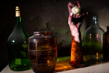 Close up of wrinkled hand with eyeball between glass jars