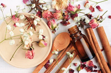 Poster Essential oil of rose, cinnamon, anise mix. Herbal aroma beauty care. Dropper bottle, dried fragrant flowers, sticks, wooden utensils, top view background. © Anna_ok