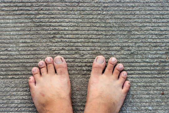Top View of Bare Foot on Cement Floor Background. Walk to the Na