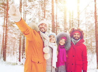 group of smiling men and women in winter forest