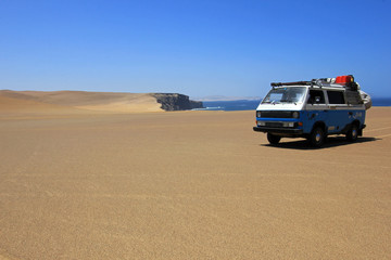 Fototapeta na wymiar Van at paracas ocean front in the sand dunes