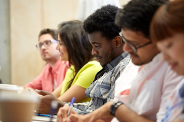 group of international students writing at lecture