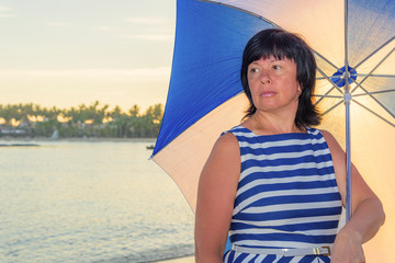 brunette woman with a beach umbrella