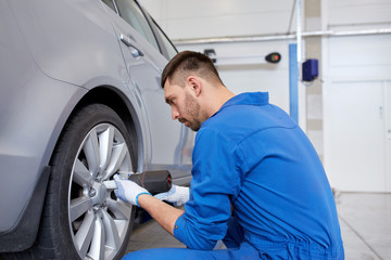 Fototapeta na wymiar mechanic with screwdriver changing car tire