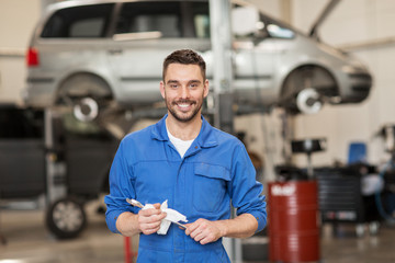 auto mechanic or smith with wrench at car workshop
