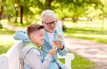 Naklejka premium old man and boy eating ice cream at summer park