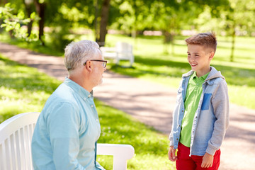 Obraz premium grandfather and grandson talking at summer park