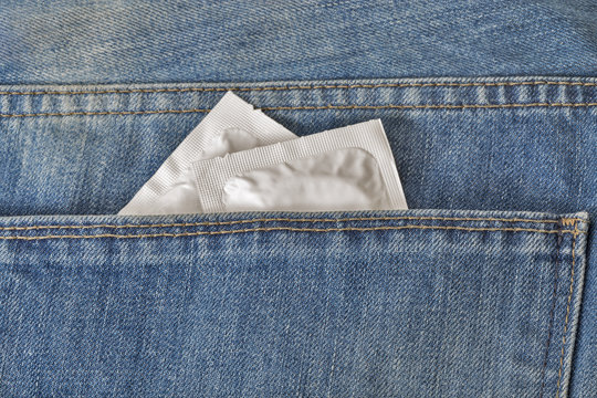 Condoms in the pocket of a blue jeans closeup