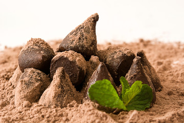 Homemade chocolate truffles and mint isolated on white background

