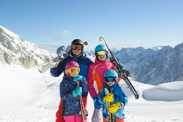 Happy family enjoying winter vacations in mountains . Ski, Sun, Snow and fun.