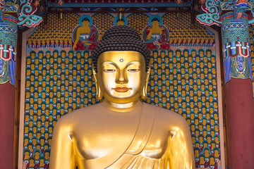 A big golden Buddha statue inside an ancient temple