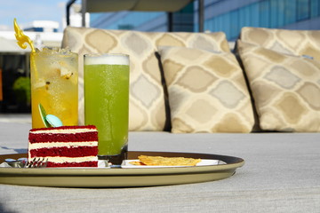 cocktail with red velvet cake and snack serve at outdoor bed - evening sunlight with select and soft focus