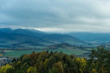 Naklejka premium Seasonal landscape with morning fog in valley. Clouds drenched valley below the level of the mountains