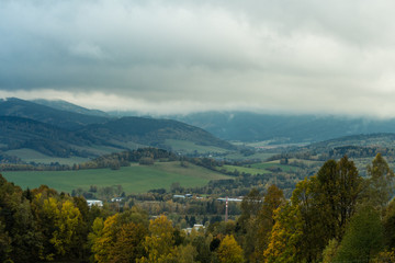 Seasonal landscape with morning fog in valley. Clouds drenched valley below the level of the mountains