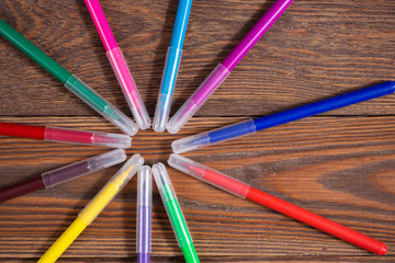 Fototapeta premium colored felt-tip pens on a wooden table background, the concept