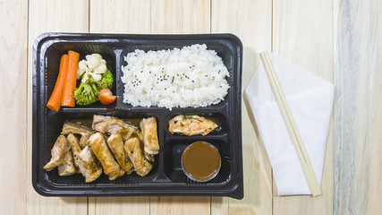 pork chop kurobuta steak Japanese style in bento set on plastic box with wooden background