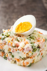 Russian salad on rustic wooden table

