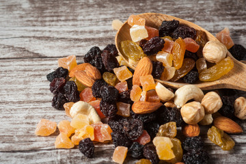 Nuts and dried fruits mix on a rustic sack and wooden background
