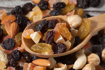 Nuts and dried fruits mix on a rustic sack and wooden background