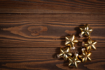 Fototapeta na wymiar Christmas toys golden stars on wooden background concept Chris