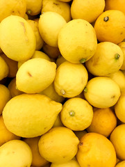 Close-up detail on a stack of yellow lemons. Food and agriculture concept.