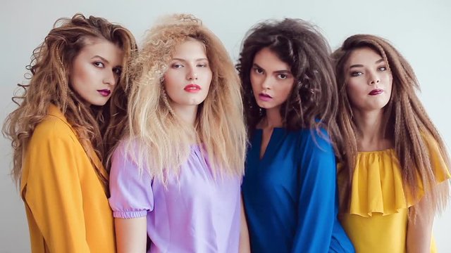 Fashion girls with professional makeup and crazy hair style, posing over white background.