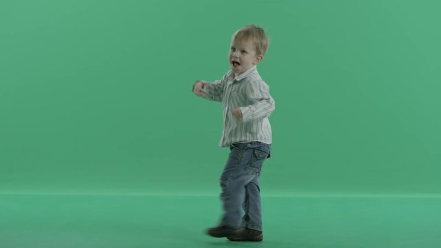 Little Boy Is Dancing Against Green Screen Background