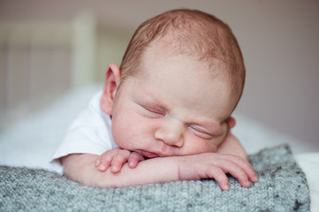 Newborn baby boy lying on bed, sleeping, close up