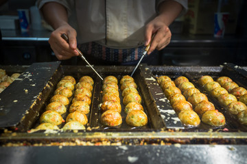 japanese chif cooking takoyaki, tagoyaki is the most popular del