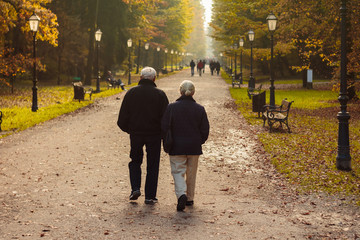 Elderly couple walking in park in autumn