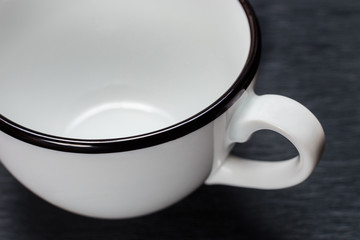 empty white cup with black ends, on a black background
