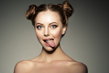 Emotional girl. Beautiful modern model shows tongue Positive wom