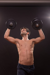 young man worship weights arms raised outstreched