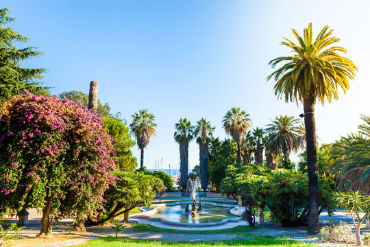 Nobel gardens with a fountain in the foreground, Sanremo, Italy. Classic garden with palm trees and flowers.