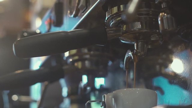 Slowmotion. Preparation of espresso. Coffee Machine. A cup of espresso. Vivacity. Barista makes a cup of coffee for the visitor. Preparing cups of espresso at a busy coffee shop.