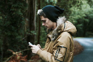 boy with mobile phone in the forest