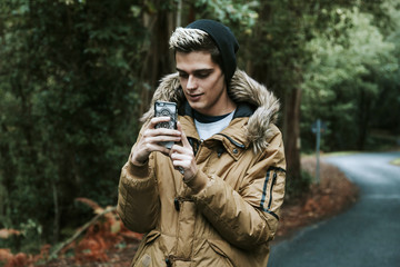 Obraz premium boy with mobile phone in the forest