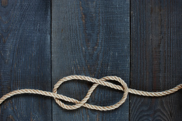 Knot of rope on the wooden background